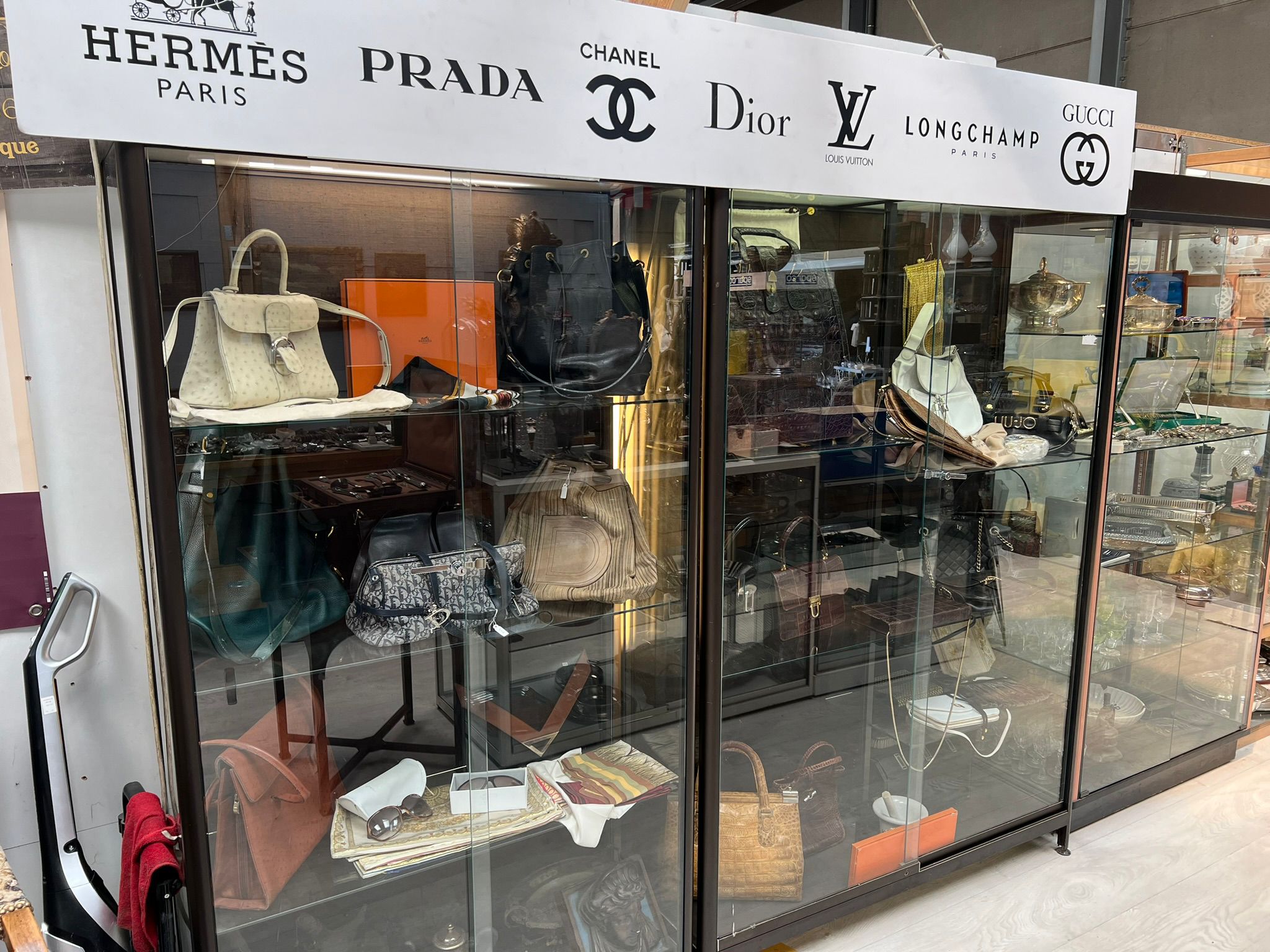 Vitrine de sacs de luxe Hermès, Prada, Chanel, Dior, Louis Vuitton