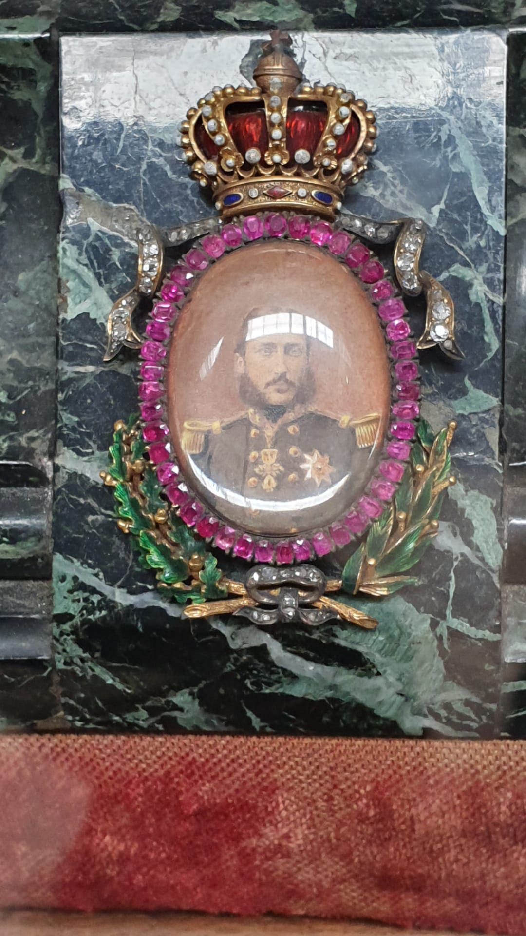 Médaillon portrait royal couronné serti de rubis et diamants sur marbre vert