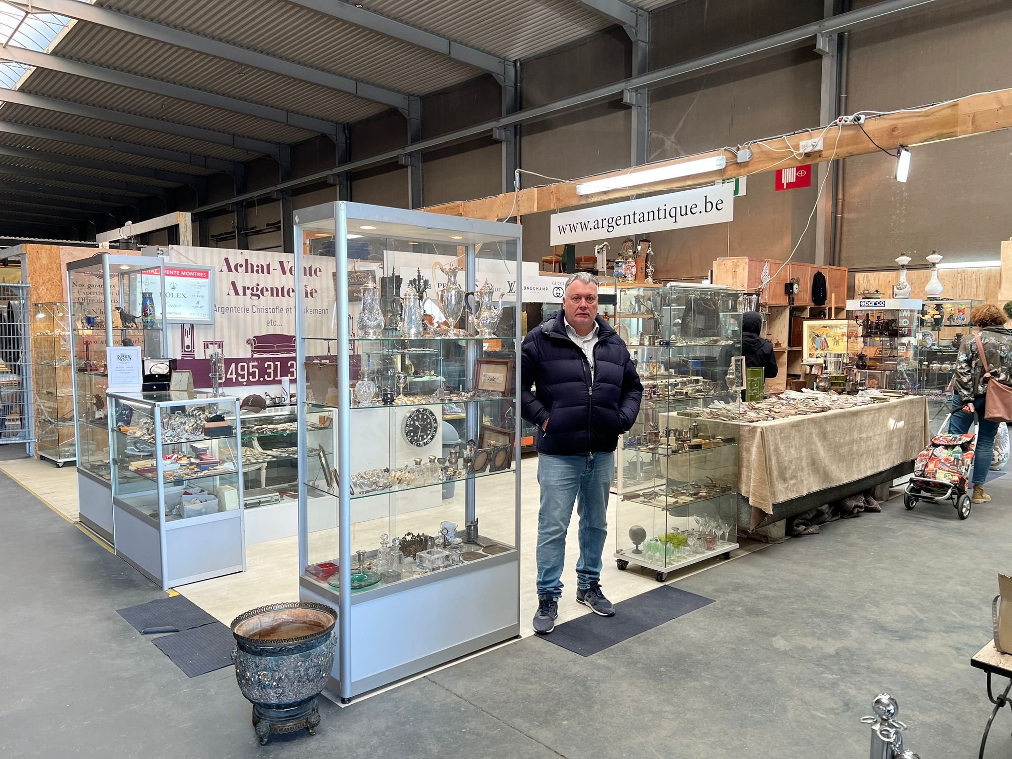 Philippe BERNIER & fils sur son stand au marché antiquaire, vitrines de montres, argenterie et objets de collection
